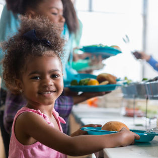 little girl in soup kitchen