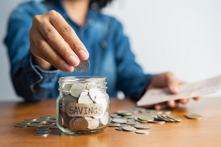 Woman putting coins in a jar